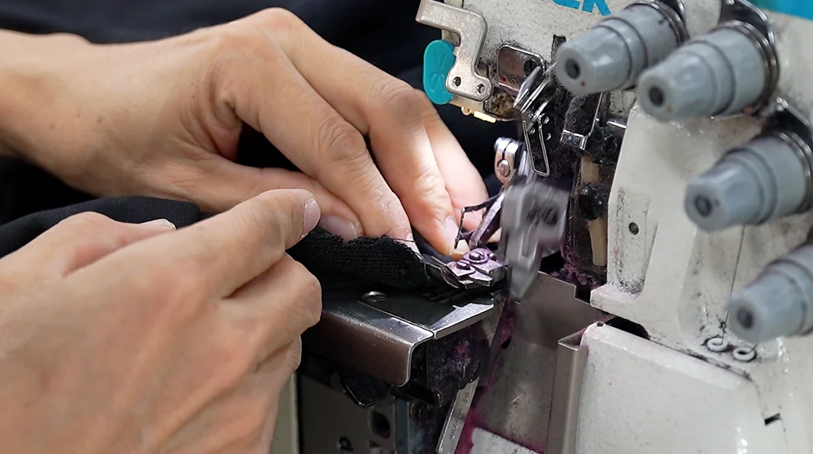 Hands guiding fabric on sewing machine